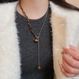 Tiger eye stone bead necklace with silver metal Y-chain shown on a model's neck