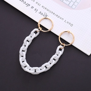 Detail of white acrylic thick chain strap with gold metal rings for clogs and bags