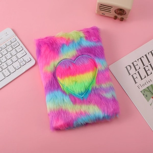 Rainbow plush cat notebook with heart embroidery on a desk with cute accessories