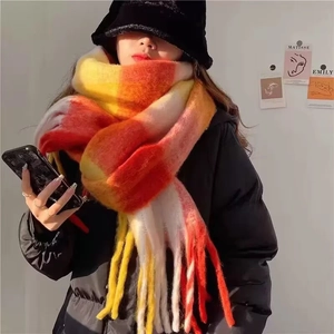 Detail of colorful plaid scarf with soft rainbow fringe and warm knitted texture