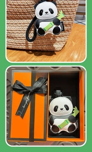 Detail of leather panda bag charm with bamboo, including premium orange gift box packaging