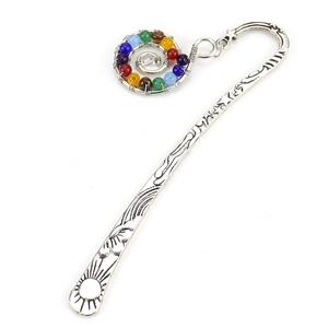 Macro view of silver metal bookmark with spiral pendant and colorful chakra beads