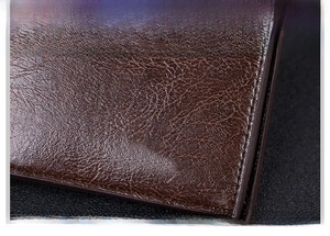 Close-up of premium brown litchi-grain leather texture with refined polished finish