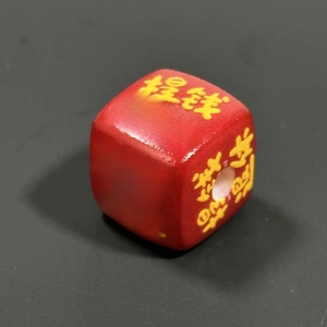 Macro shot of red square acrylic bead featuring yellow Tiqian Tuixiu typography
