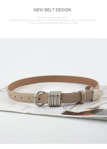 Macro detail of slim leather belt with silver circular buckle and metal ring accents