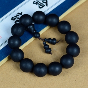 Vue détaillée de 12 perles bouddhistes en bois noir avec pendentifs hulu et texture zen