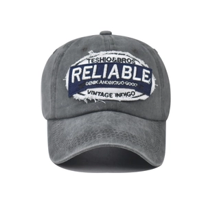 Detailed view of embroidery on charcoal grey washed cotton baseball cap with distressed texture