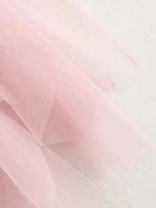 Detailed close-up of soft pink layered mesh fabric showing delicate tulle texture and folds