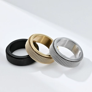 Three-piece stainless steel spinner rings in black, gold, and silver with woven mesh texture