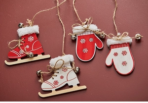 Detail of wooden Christmas ornaments featuring skate and mitten shapes with snow patterns