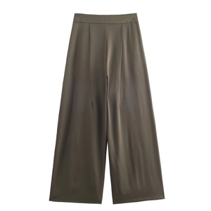 Détail du pantalon taille haute vert olive avec finition satinée et plis élégants