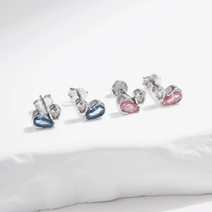 S925 sterling silver heart stud earrings with blue and pink stones on stone surface