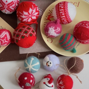 Detail of red and white knitted Christmas tree ornaments with soft wool textures