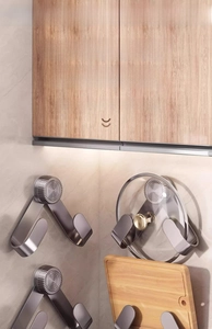 Strong suction cup pot lid rack holding a glass lid and heavy wooden cutting board
