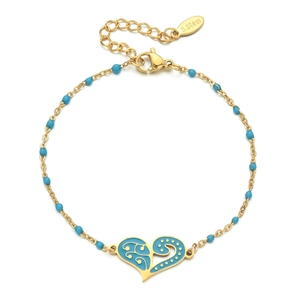 Macro detail of gold stainless steel bracelet featuring a blue heart enamel pendant