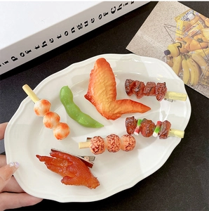 Detailed view of six funny simulation food hair clips including wings and meat on a plate