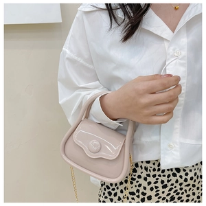 Mini jelly handbag in nude pink with golden chain strap shown on a model