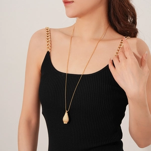 Detail of a long gold beaded sweater necklace with a textured water drop acorn pendant