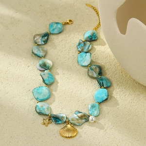 Detail of ocean-style necklace with turquoise shells, golden starfish and conch pendants