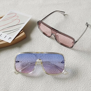 Detail of pink and blue gradient oversized sunglasses with clear frames on display