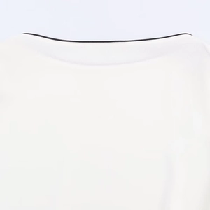 Detailopname van de witte chiffon blouse halslijn met contrasterende zwarte biesrand
