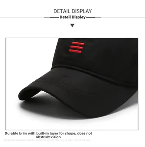 Detail view of the black baseball cap showing sturdy brim with red stripe embroidery