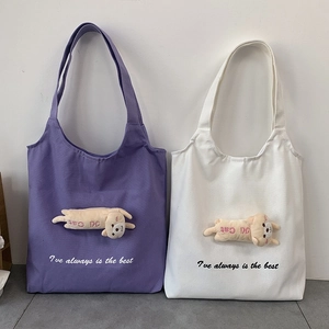 Detail of purple and white canvas tote bags with 3D plush cat doll and letter print
