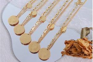 Macro shot of 18k gold plated portrait coin pendant with unique paperclip chain link detail