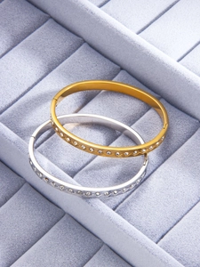 Detail of luxury gold and silver diamond bangles in a rhombic geometric design