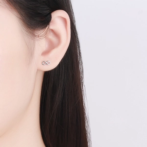 S925 sterling silver infinity symbol screw back stud earrings worn by a model