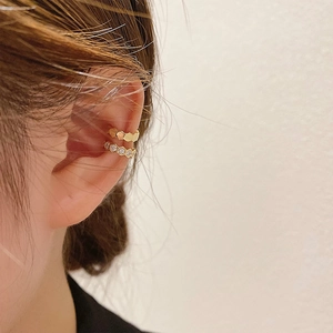 Elegante brazalete de oreja de panal dorado con circonita en la oreja de una modelo de cerca