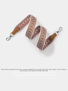 Detail of woven fabric shoulder strap with brown leather ends and silver metal hooks