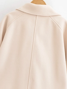 Close-up of stitching and texture on beige wool coat collar with wooden hanger