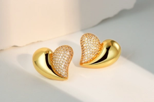 Macro shot of gold heart stud earring with half polished finish and half pavé zircon stones