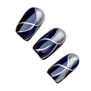 Faux ongles bleu marine avec paillettes argentées et motifs de lignes ondulées blanches