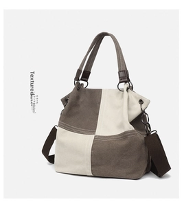 Detail of a retro canvas tote bag featuring contrast stitching and matte metal hardware