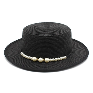 Detailed close-up of a black boater hat with elegant pearl embellishments and straw texture