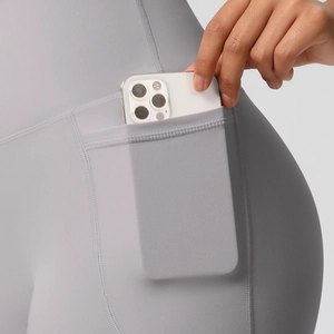 Close-up of high-waist yoga shorts showing the functional side pocket with a smartphone