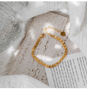 Dettaglio ravvicinato di un bracciale vintage dorato a coda di pesce con ciondolo a cuore