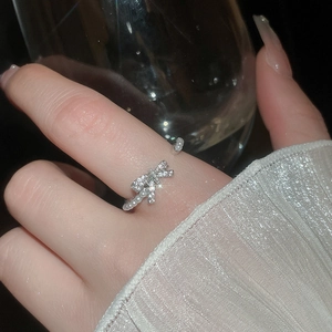 Close-up of elegant bow pearl ring with sparkling zircons and adjustable silver band