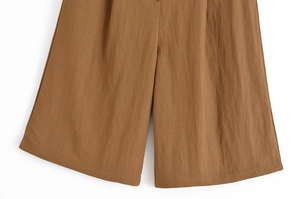 Detail of brown wide-leg shorts featuring textured fabric and sharp tailoring details
