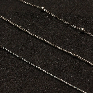 Three minimalist silver stainless steel necklace chains in bead and cross-link styles