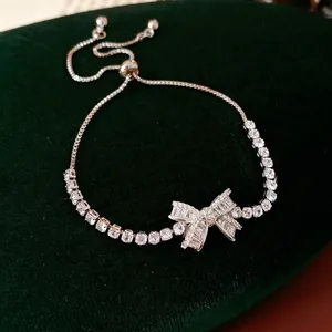 Elegant silver adjustable bow bracelet with sparkling cubic zirconia on green velvet