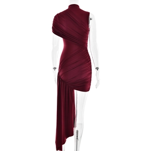 Detail of burgundy one-shoulder dress showing elegant ruched fabric and asymmetrical ribbon hem