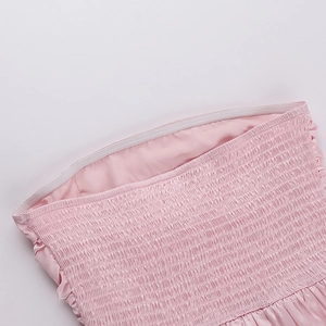 Close-up of pink smocked mini dress showing elasticated texture and non-slip silicone strip
