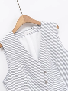 Détail du gilet à rayures bleues et blanches montrant la texture sur cintre en bois