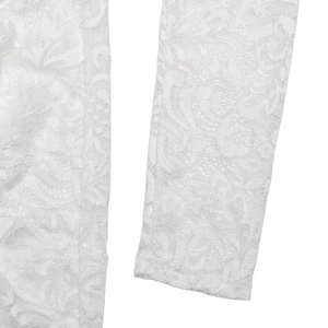 Detailed close-up showing the intricate white lace texture and floral patterns of the dress