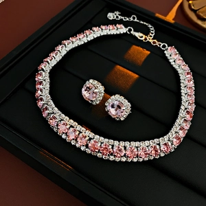 Close-up of pink gemstone jewelry set including necklace and earrings on black display tray