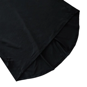 Détail de l'ourlet incurvé de la robe noire avec une couture double de qualité