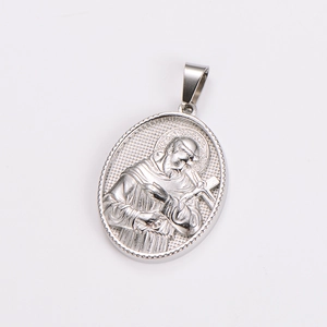 Macro detail of silver oval pendant featuring a religious figure relief in stainless steel